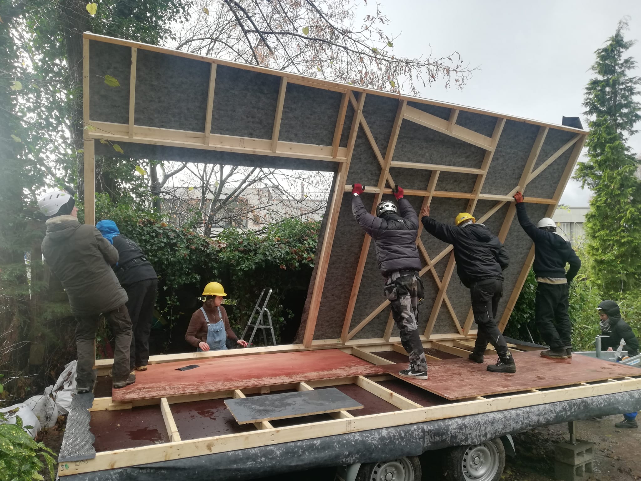 Participants relevant un mur en ossature bois sur la remorque de la tiny house