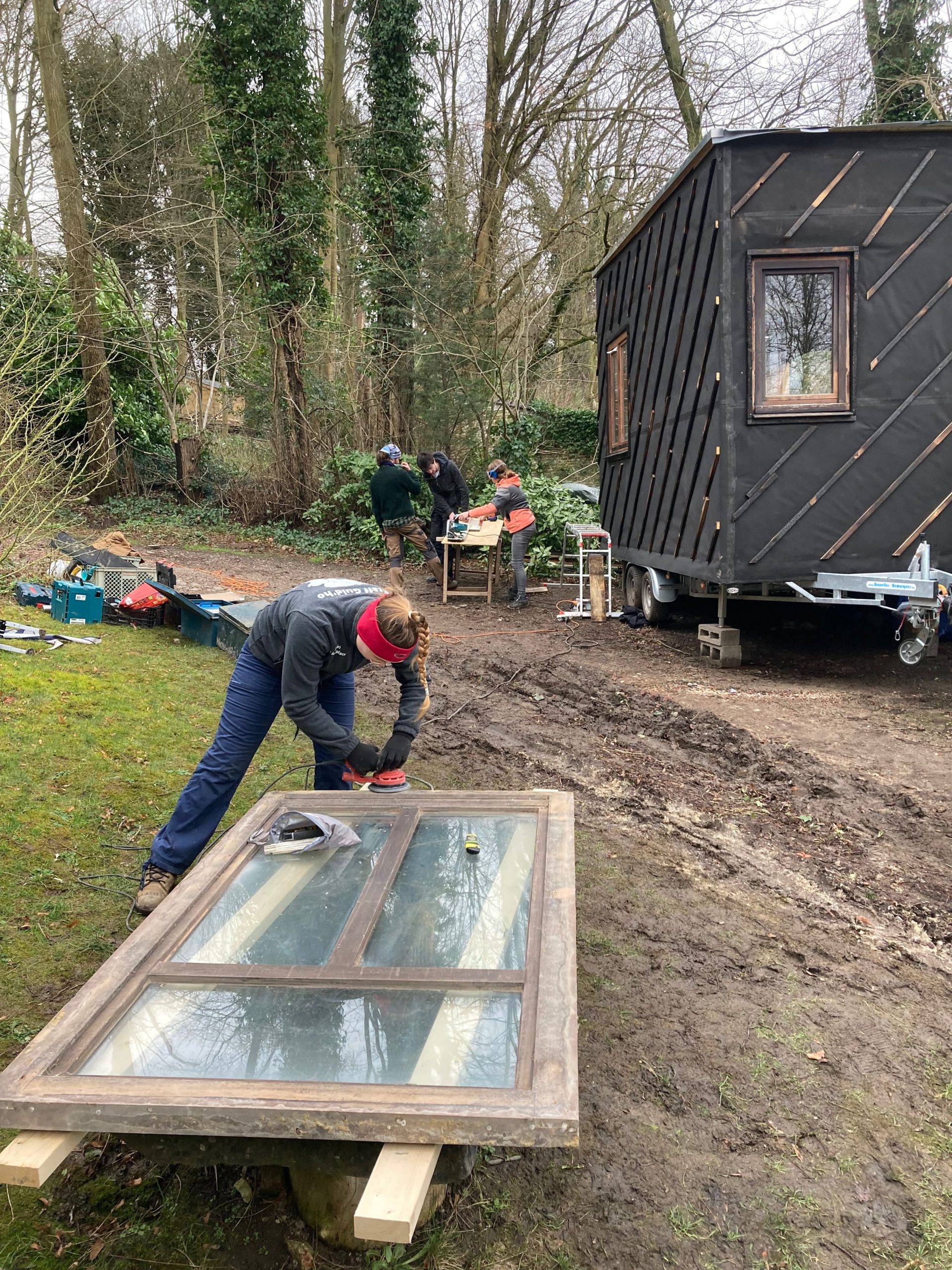 La tiny house en fond de jardin, un participant prépare un châssis