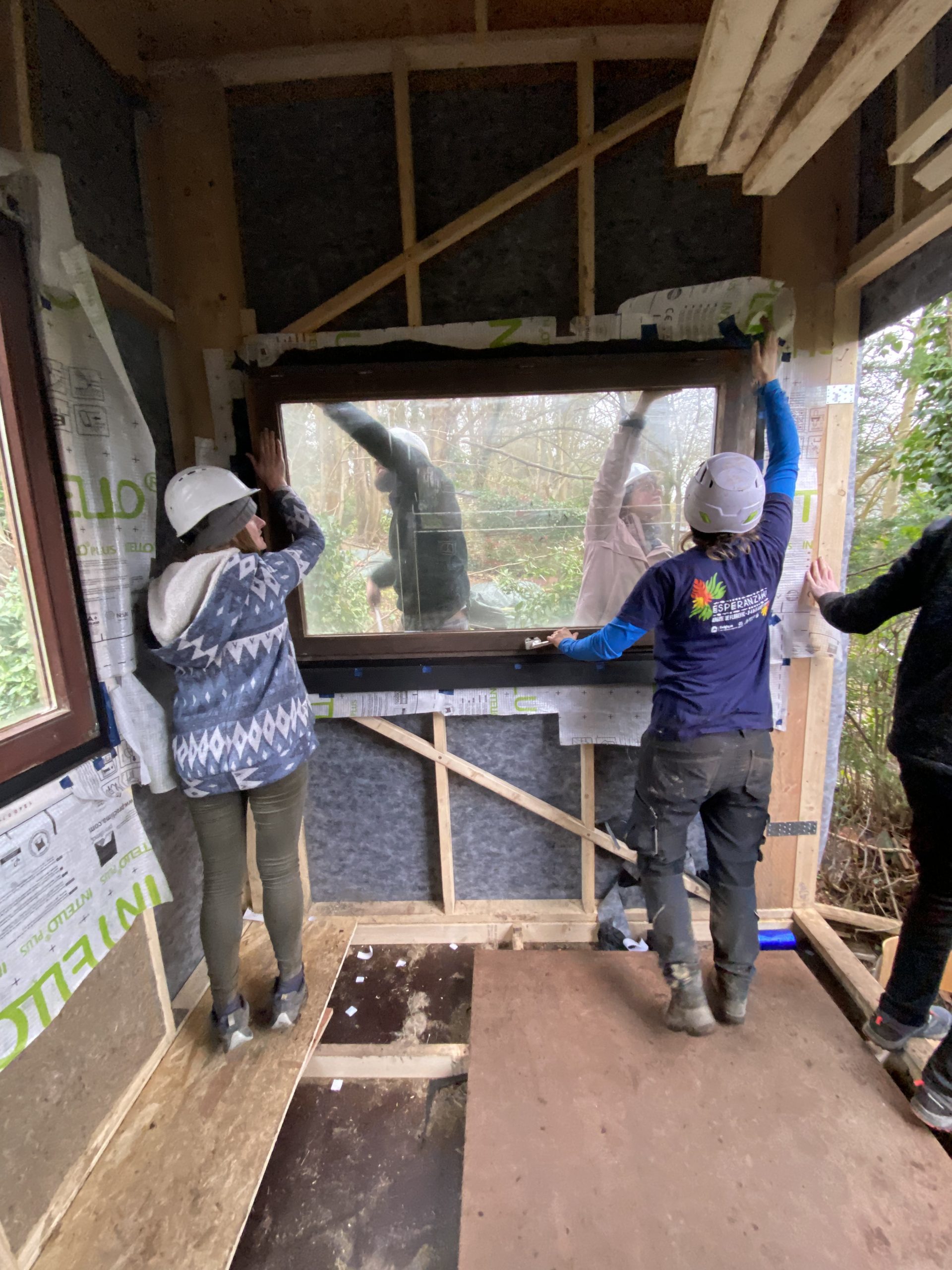 Participants ajustant une ouverture depuis l'intérieur de la tiny house