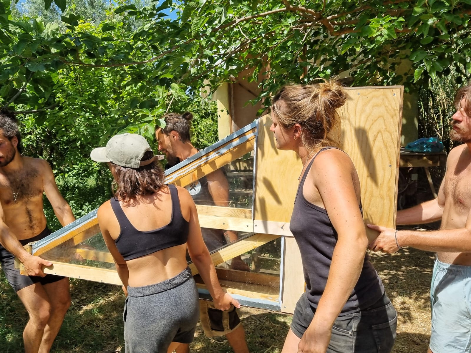 Participants transportant un panneau bois vers le chantier