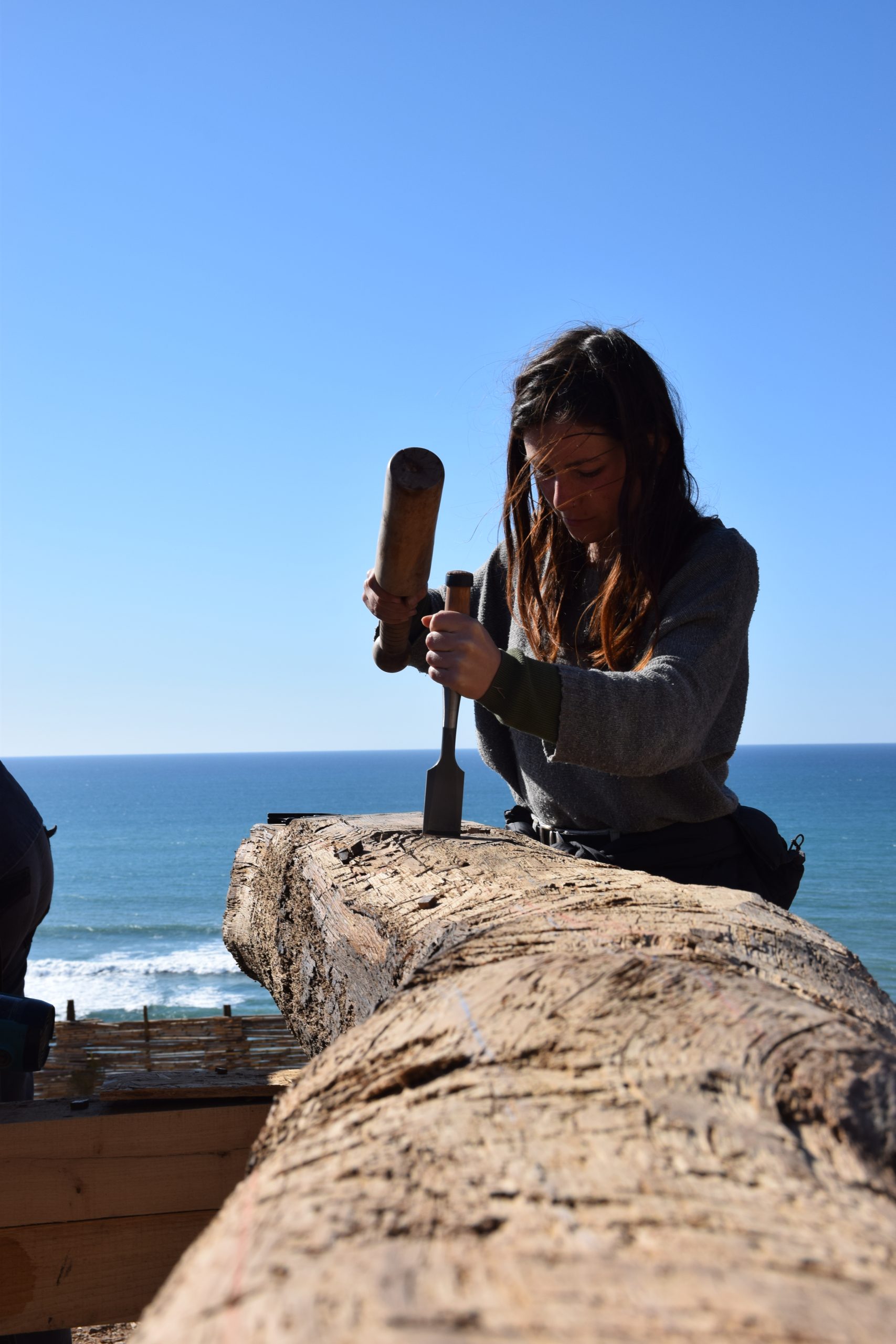 Une participante filme une poutre face à la mer