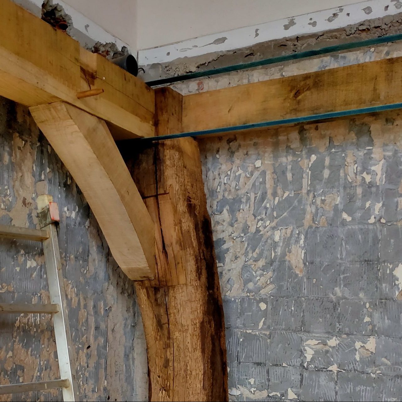 Assemblage bois en place dans un angle de mur, escalier à côté