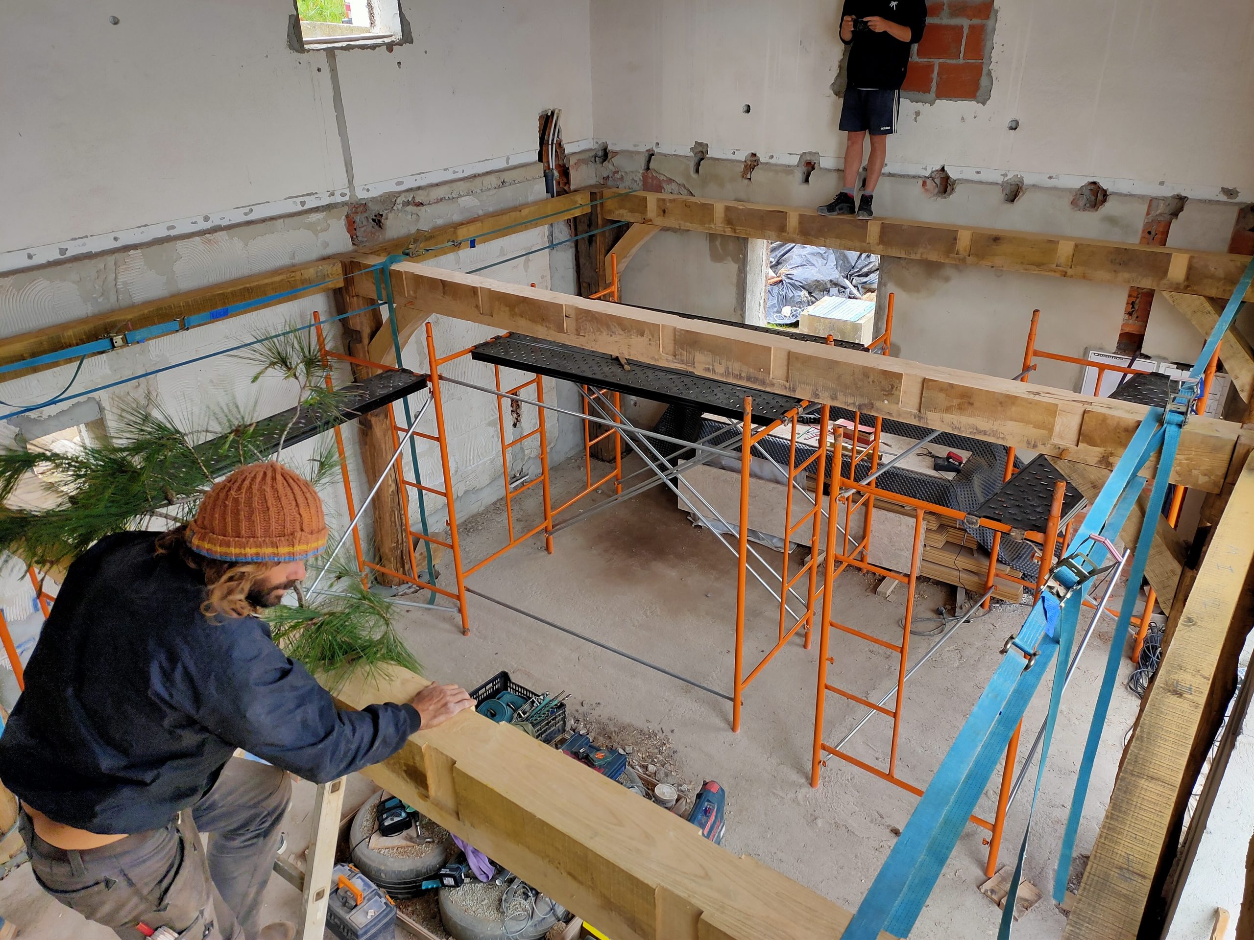 Chantier intérieur avec étais orange et charpente en cours