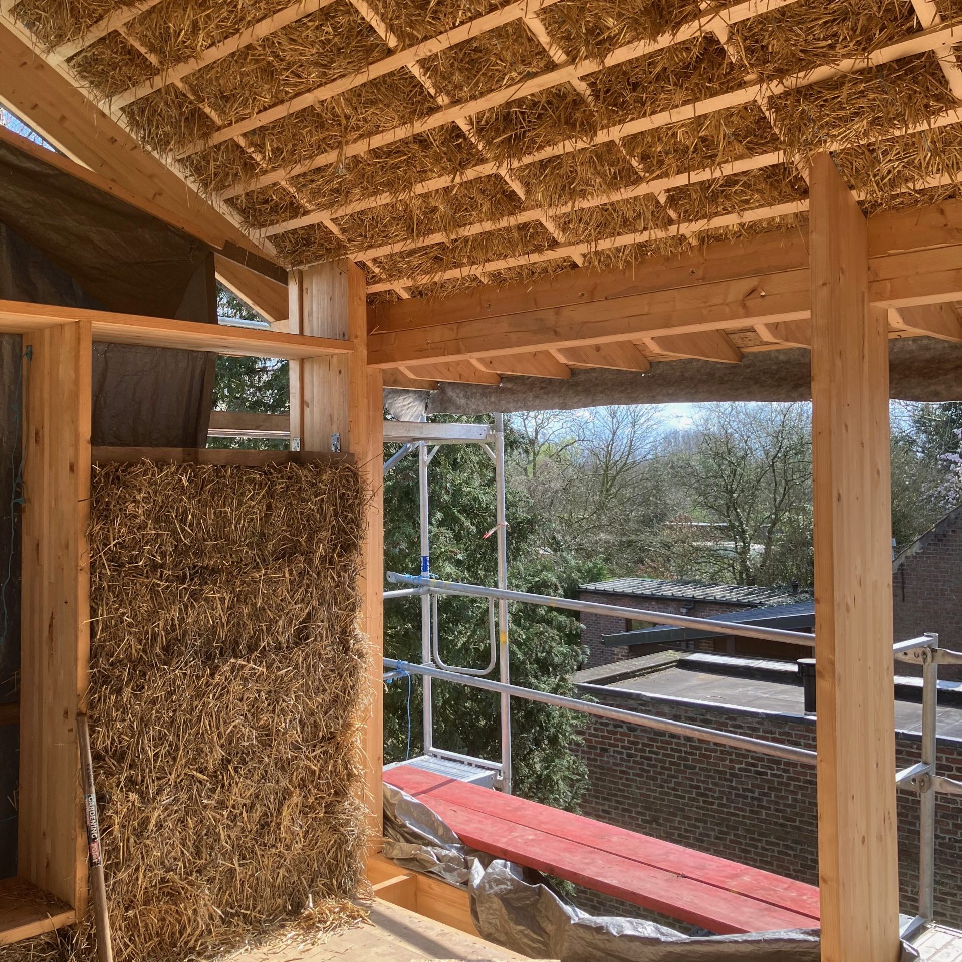 Intérieur en ossature bois, mur en ballots de paille près d'une baie